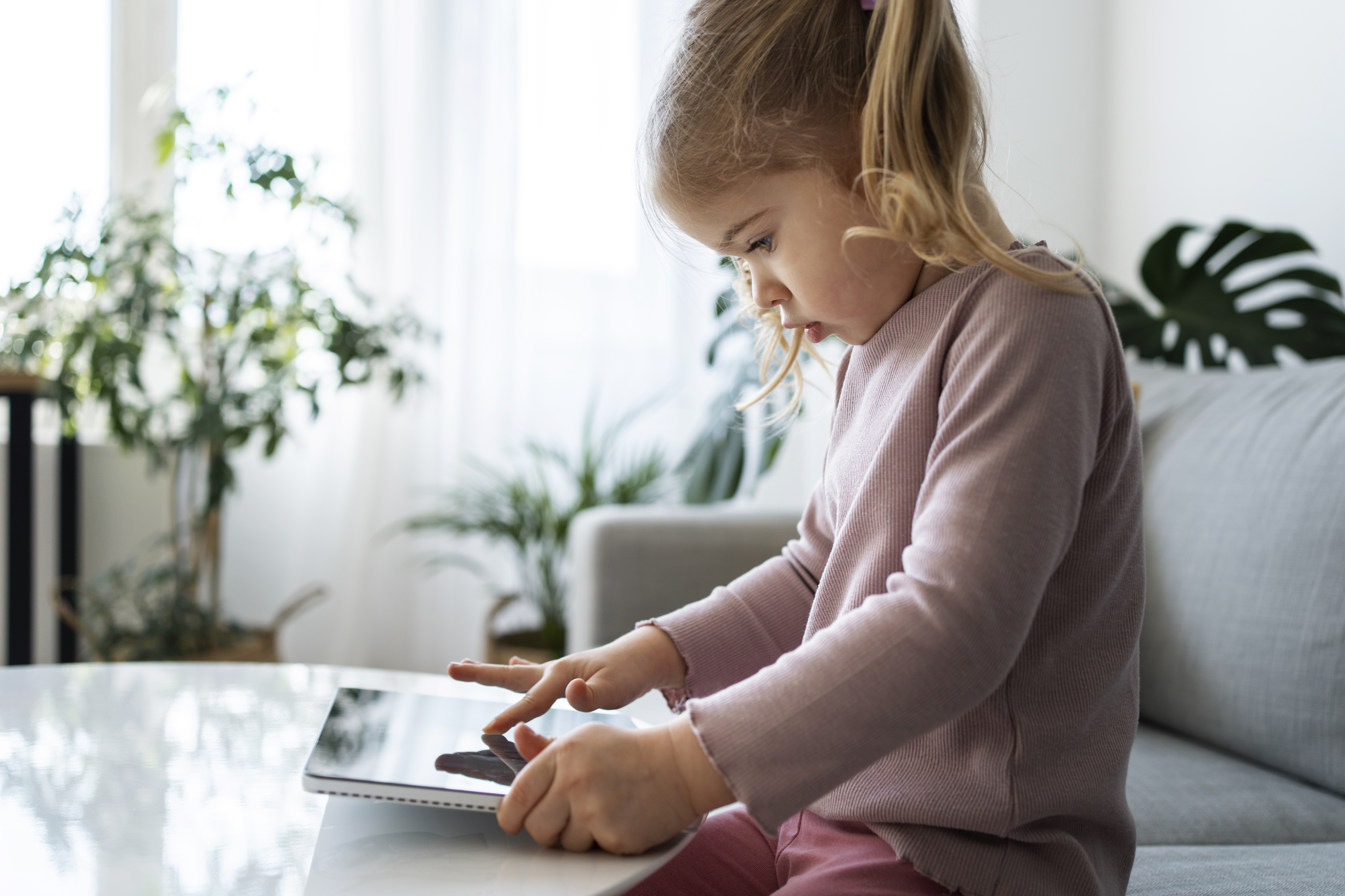 medium-shot-little-girl-with-tablet-home